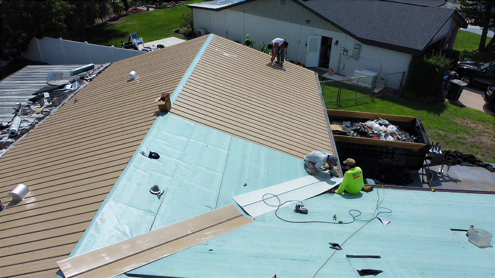 New metal roofing panels going on over fresh underlayment during a Tampa Bay metal roof install